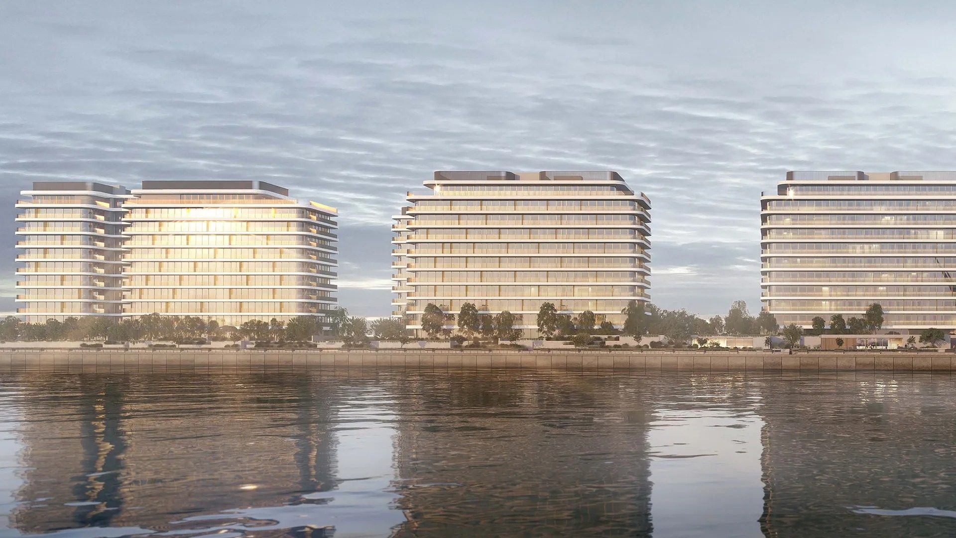 The low-rise buildings of Eden House The Park mirrored in the Dubai Water Canal at first light